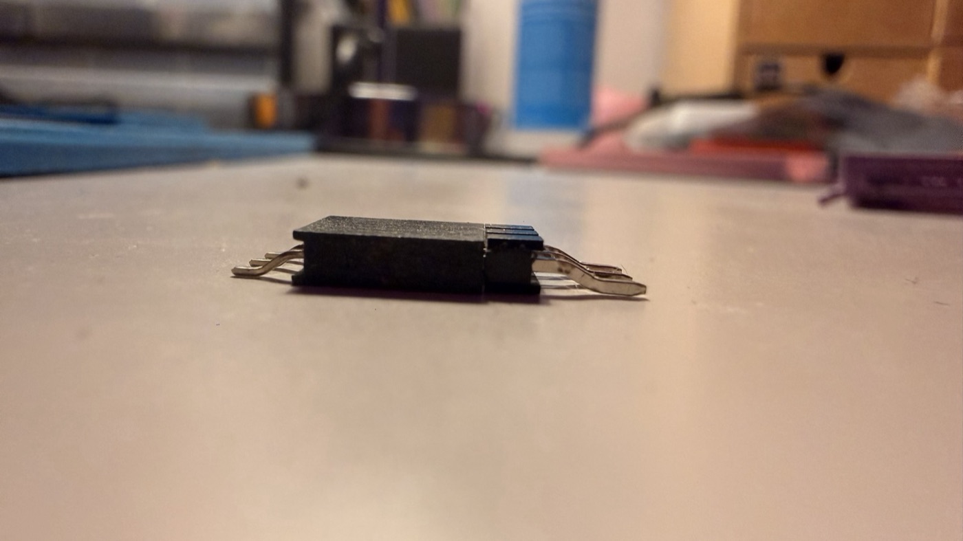A header and a socket plugged together, lying on a table